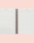 A spiral bound planner and a look at the interior that features a monthly and weekly view. 
