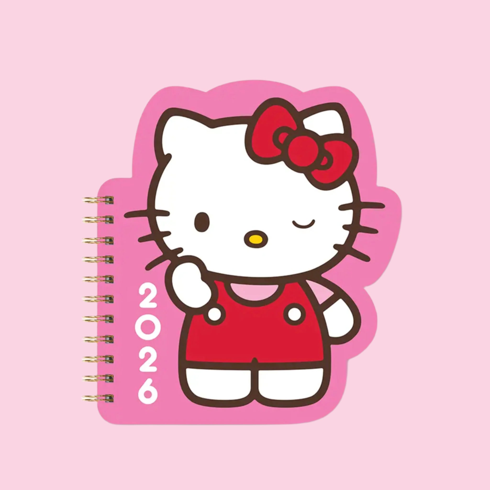 A pink and red cut out, spiral bound planner with Hello Kitty on the front along with white numbers, '2026'. 