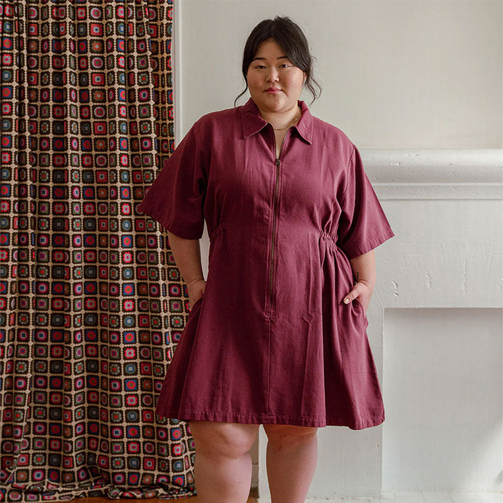 a woman wearing a burgundy colored utility mini dress