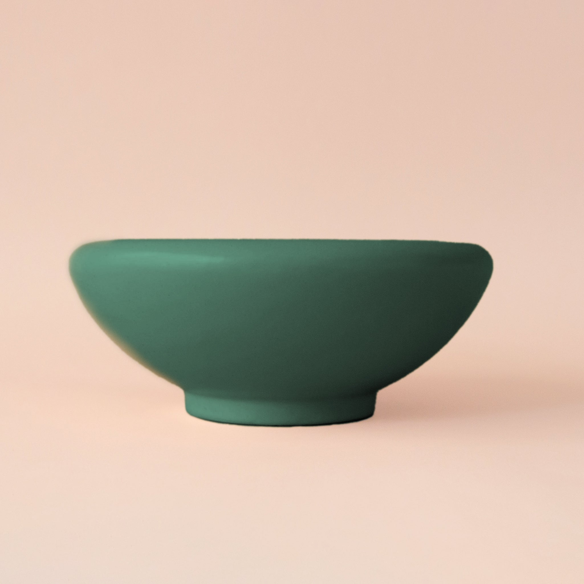 A low rounded ceramic pedestal bowl made of ceramic. 