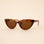 A brown tortoise print pair of cat-eye shaped sunglasses. 