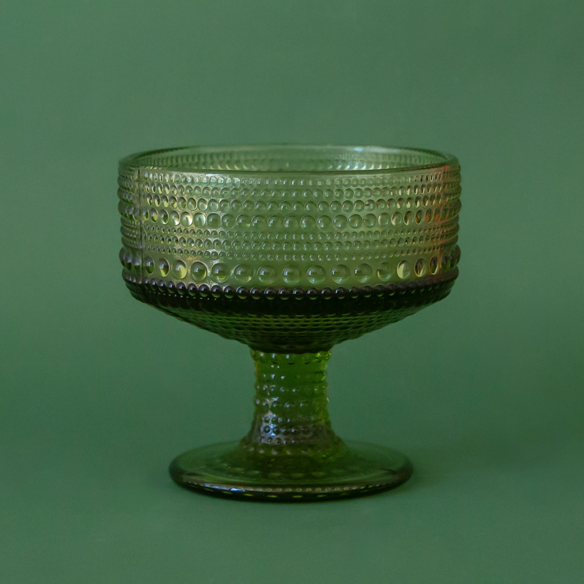 A green raised texture coupe glass. 