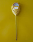 A chartreuse moisture meter with a rounded head and a white meter that ranges from dry, moist, or wet along with a small oval label in the front that reads, "Jungle Club".
