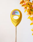 A chartreuse moisture meter with a rounded head and a white meter that ranges from dry, moist, or wet along with a small oval label in the front that reads, "Jungle Club".