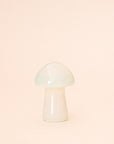 On a pink background is the larger version of the mushroom shaped opal crystal. 