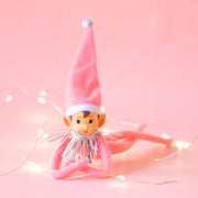 An adorable pink elf wearing a pink tall hat with silver tinsel around its neck.