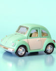 A green and white metal toy car volkswagen beetle. 