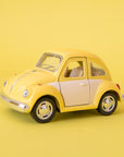 A yellow and white metal toy car volkswagen beetle.