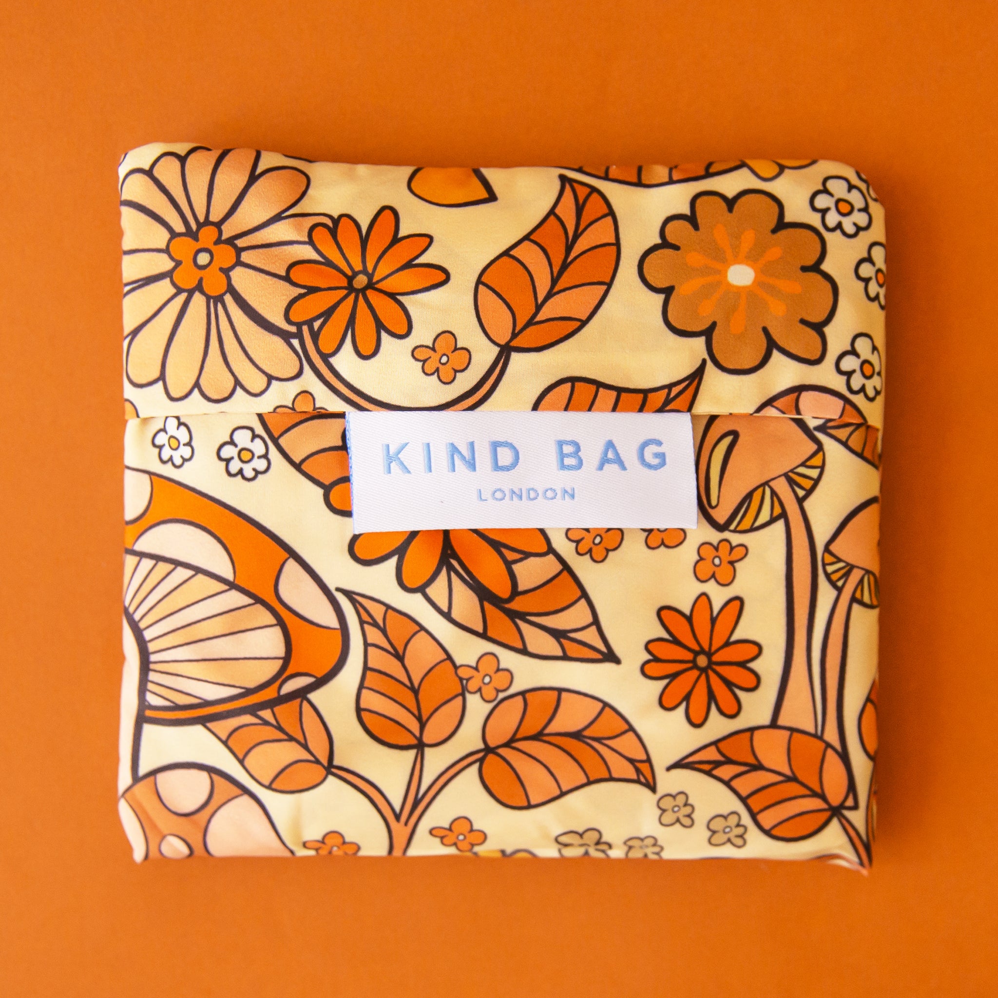 A mushroom and floral nylon reusable tote bag.
