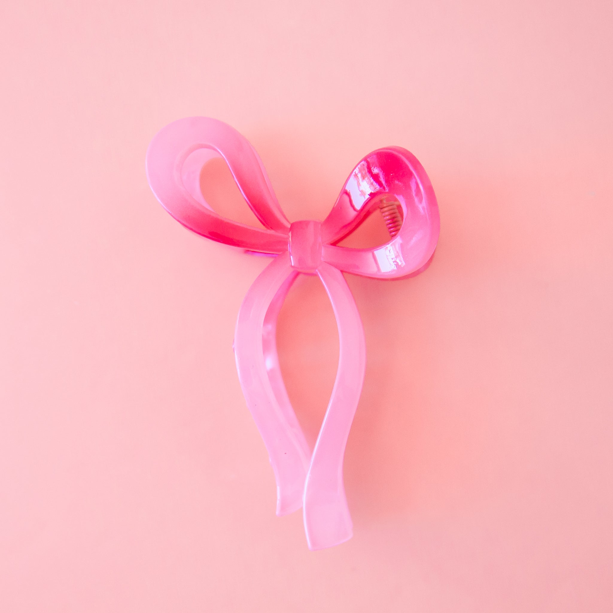 A dark pink knotted bow shaped hair claw clip. 