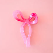 A dark pink knotted bow shaped hair claw clip. 