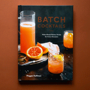 Cocktail book titled "Batch Cocktails. Make-Ahead Pitcher Drinks for Every Occasion. Maggie Hoffman." The cover image shows a tray with a pitcher of tangerine liquid, a sliced blood orange, and a knife. Two tangerine colored cocktails with lemon garnishes sit beside the tray.