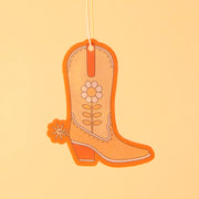 An orange cowboy boot shaped air freshener with a white string for hanging.