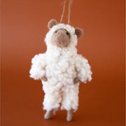 On a burnt orange background is a felt sheep shaped ornament. 