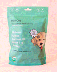 On a peach background is a green bag of dog treats with a dog graphic and text that reads, "Wild One Organic Baked Treats For Dogs".