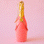 On a pink background is a coral glass champagne shaped ornament. 