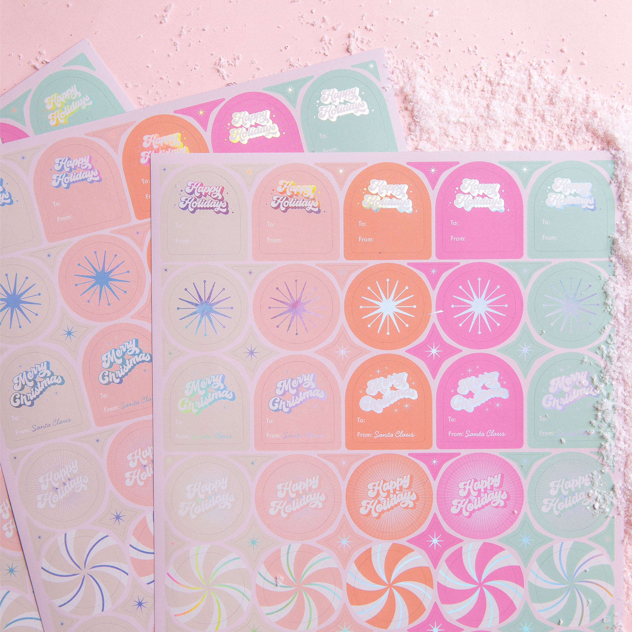 On a pink background is three sheets of gift labels with shades of pink, orange, mint and ivory along with holographic text and designs.