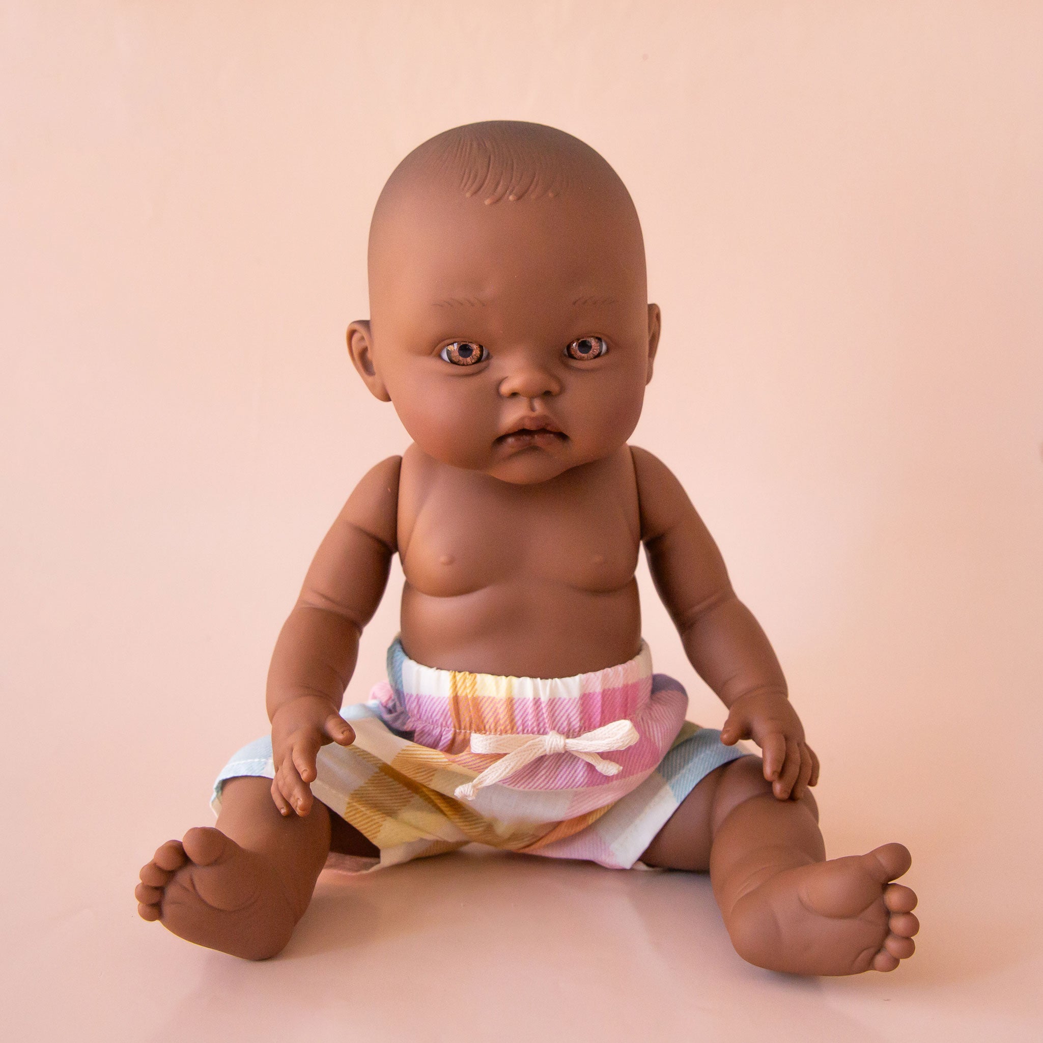 A pair of pastel checkered shorts on a Minikane doll that is sold separately.