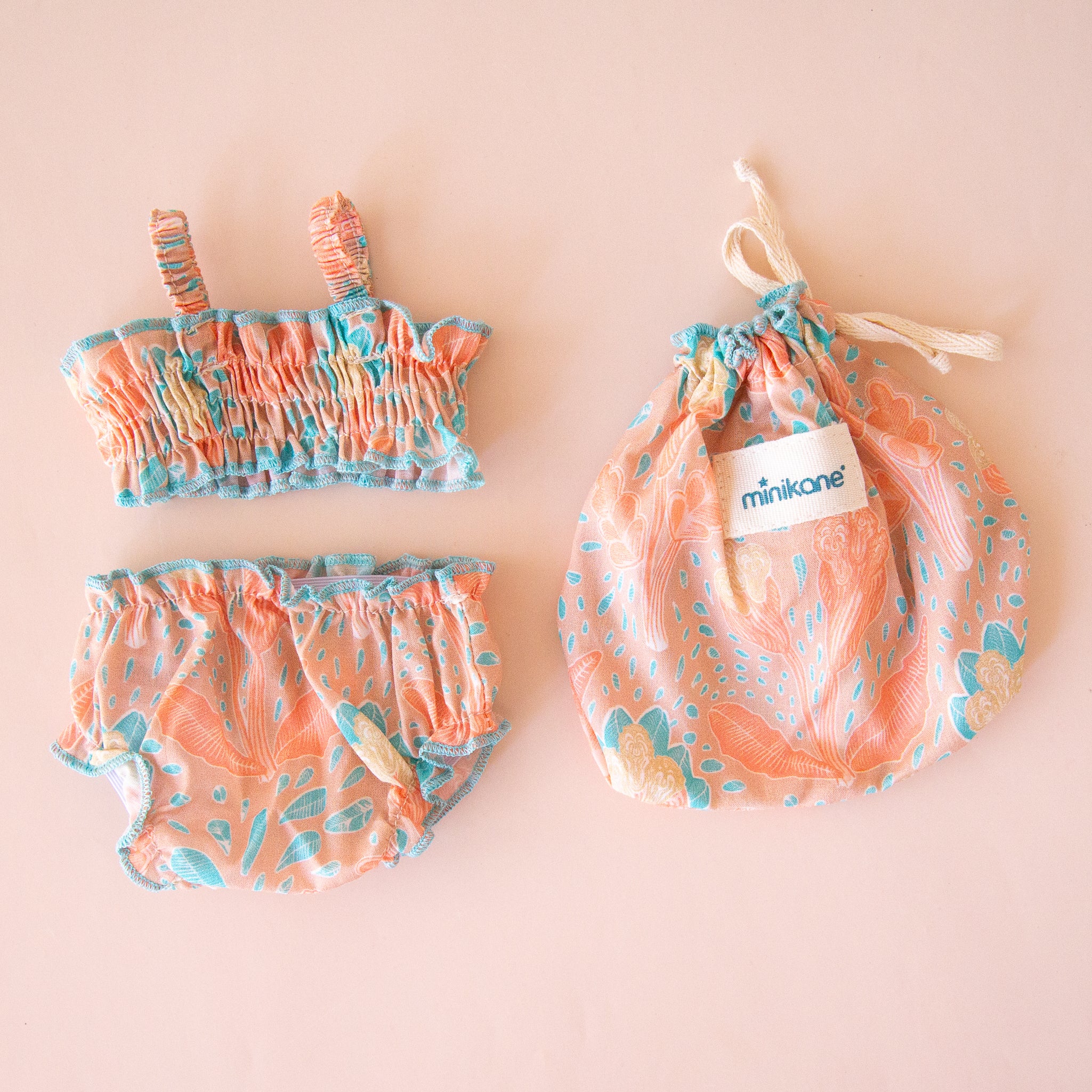 A coral and blue two piece swim suit for Minikane dolls.  Dolls sold separately. 