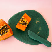 A dark green cheese board. 