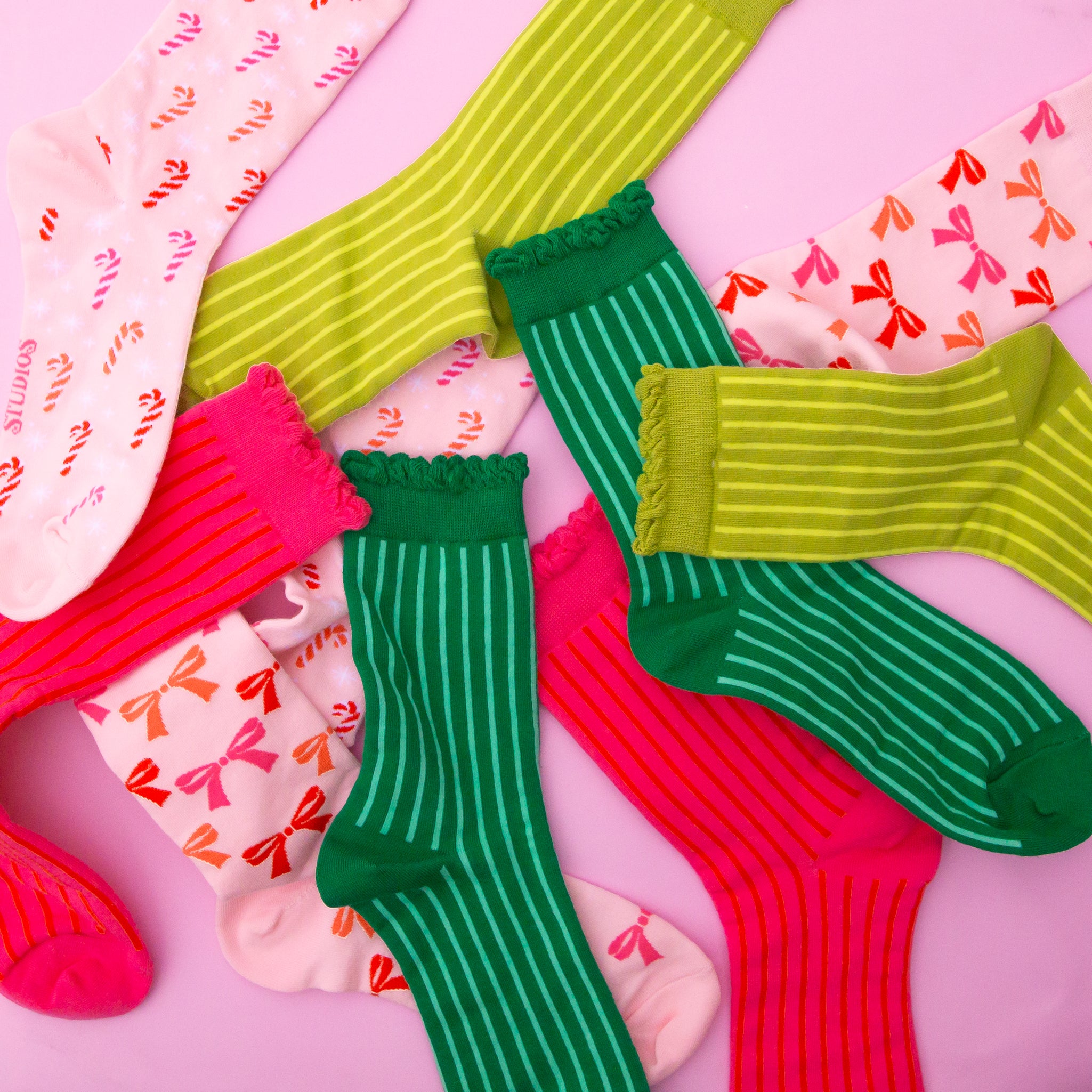 A round up photo of all of our holiday socks ranging from bow patterns, to candy cane prints, fuchsia colors and more!