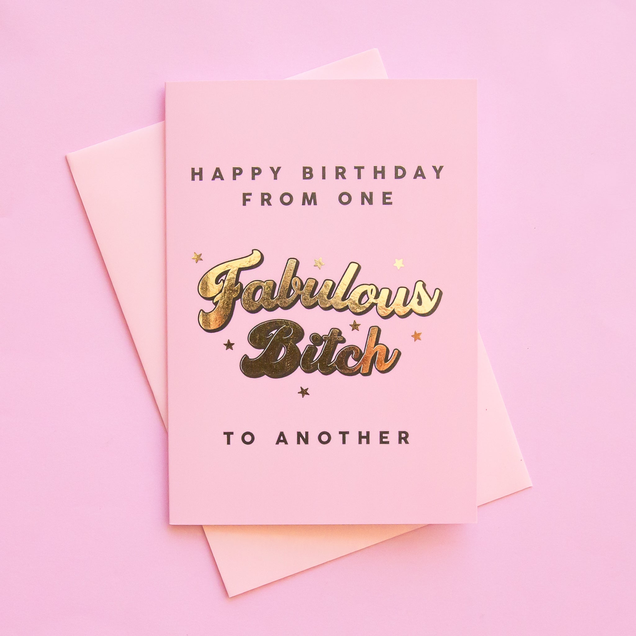 A light pink reads, &quot;Happy Birthday From One Fabulous Bitch To Another&quot; in gold font. The card is also pictured with its bright pink envelope that is included.