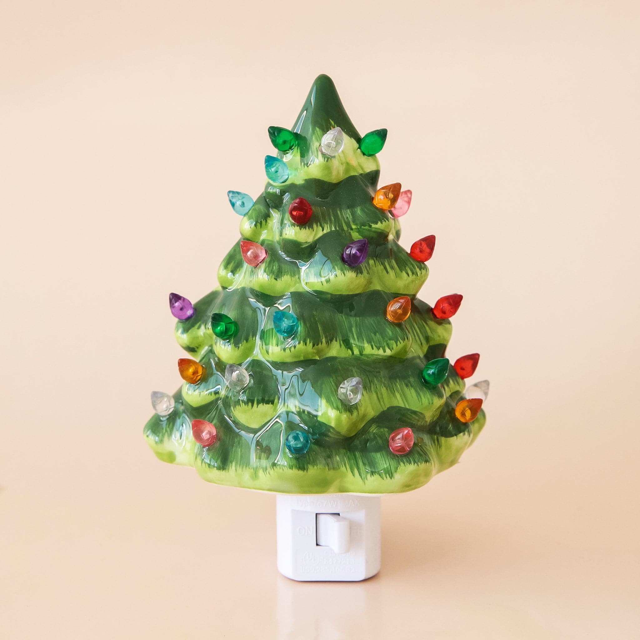 A ceramic green Christmas tree nightlight with multicolored lights all over. There is a white switch on the front of the night light so you can easily turn it on and off.