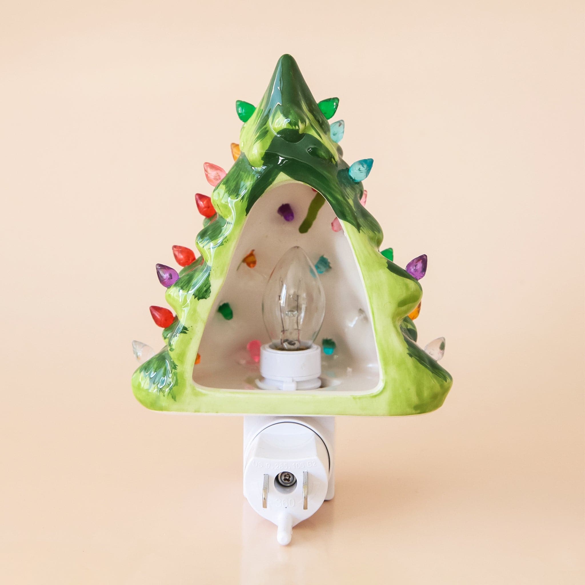 A ceramic green Christmas tree nightlight with multicolored lights all over. There is a white switch on the front of the night light so you can easily turn it on and off.