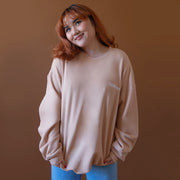 On a brown background is a peachy fleece pullover with white "California" embroidering.