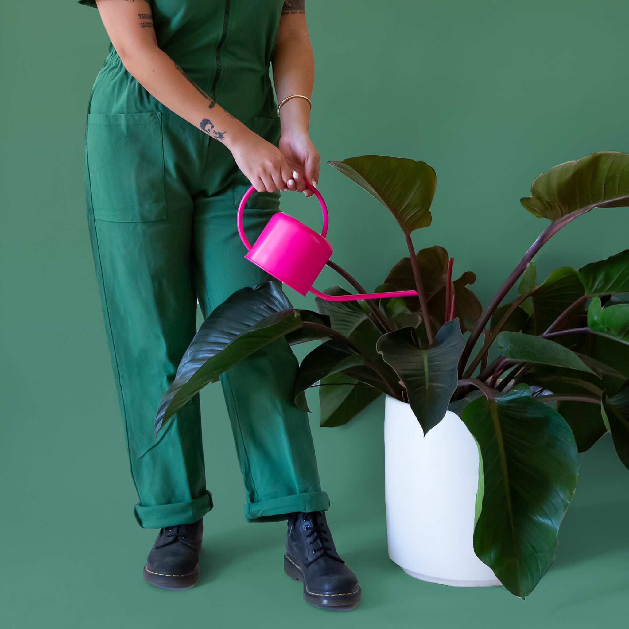 A hot pink metal watering can with a rounded handle and a long spout.