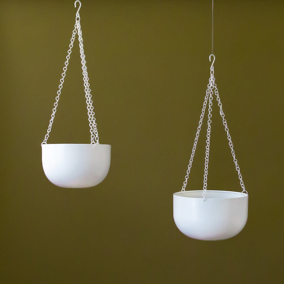 Two different sized metal white hanging planters with chain hangers. 