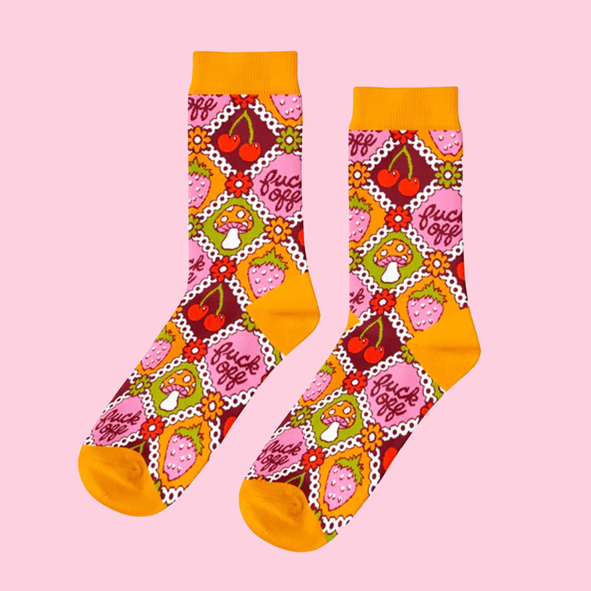 A pair of orange, pink, red and green patchwork pattern socks with designs of cherries, mushrooms, strawberries and text that reads, "fuck off". 