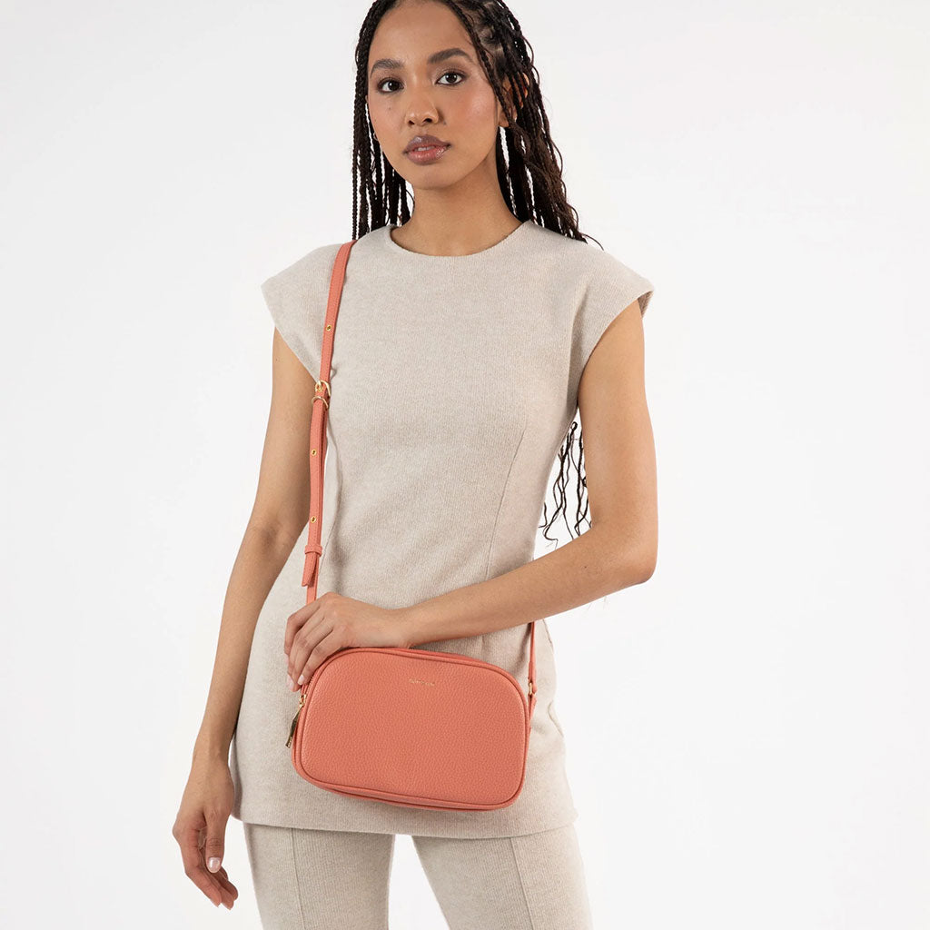 woman wearing coral colored crossbody