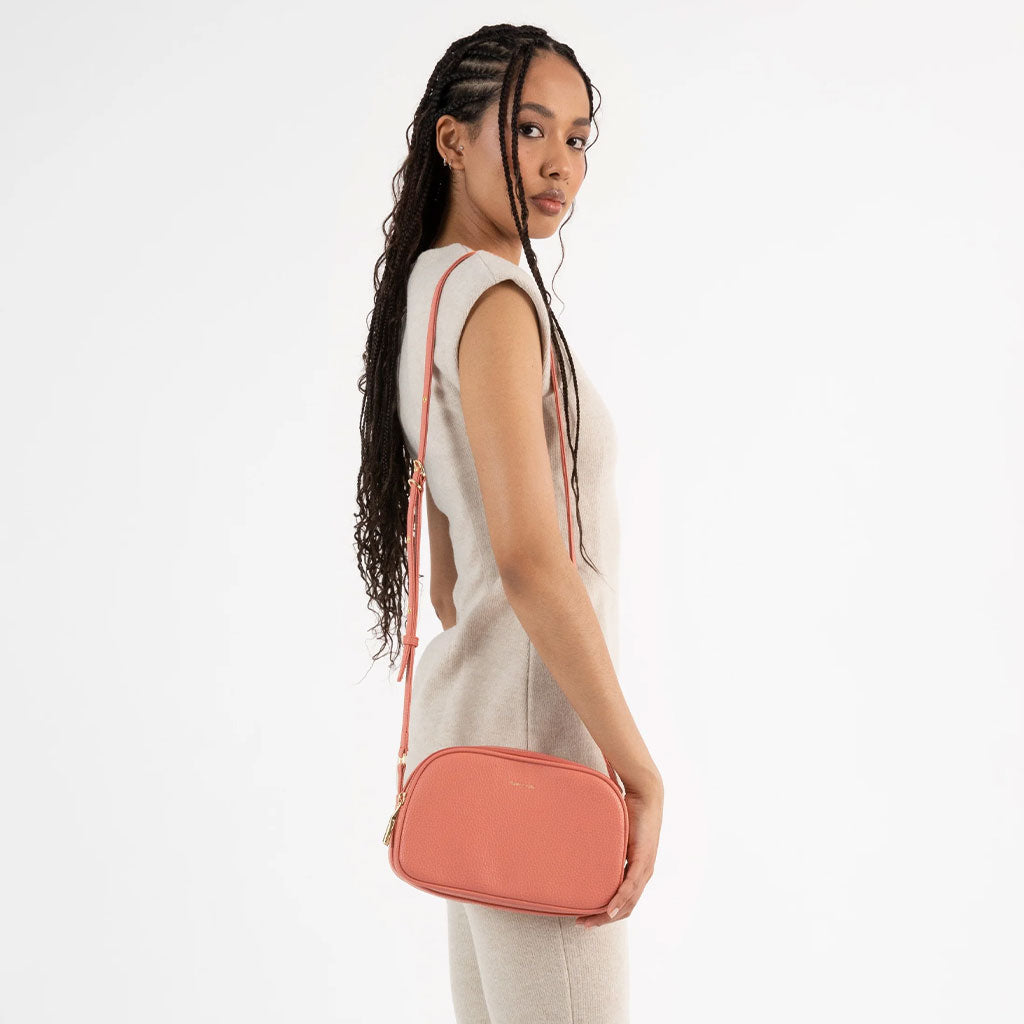 woman wearing coral colored crossbody