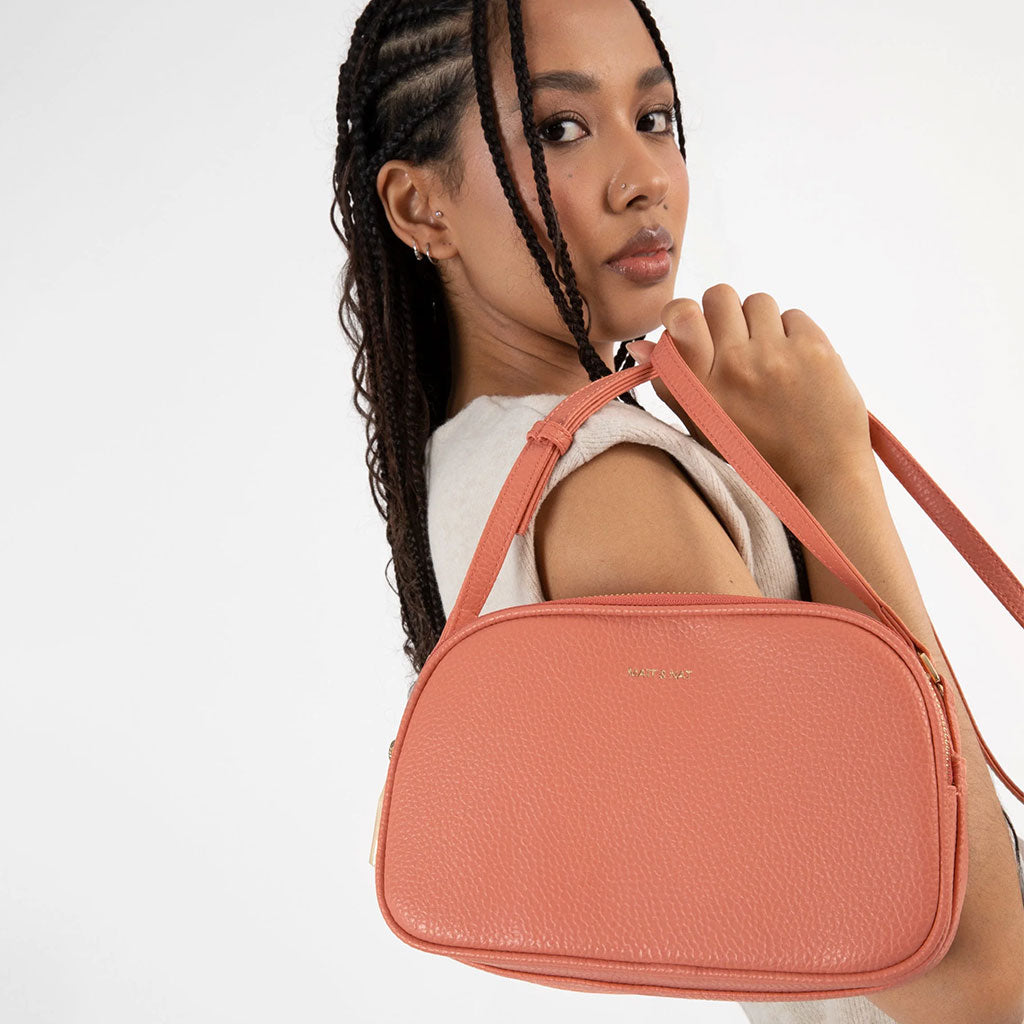 woman wearing coral colored crossbody