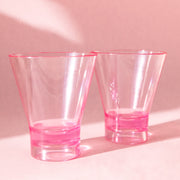 Two of the cocktail tumbler glasses in a clear pink shade. 