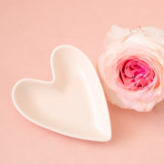 A white, ceramic, heart shaped trinket dish. 