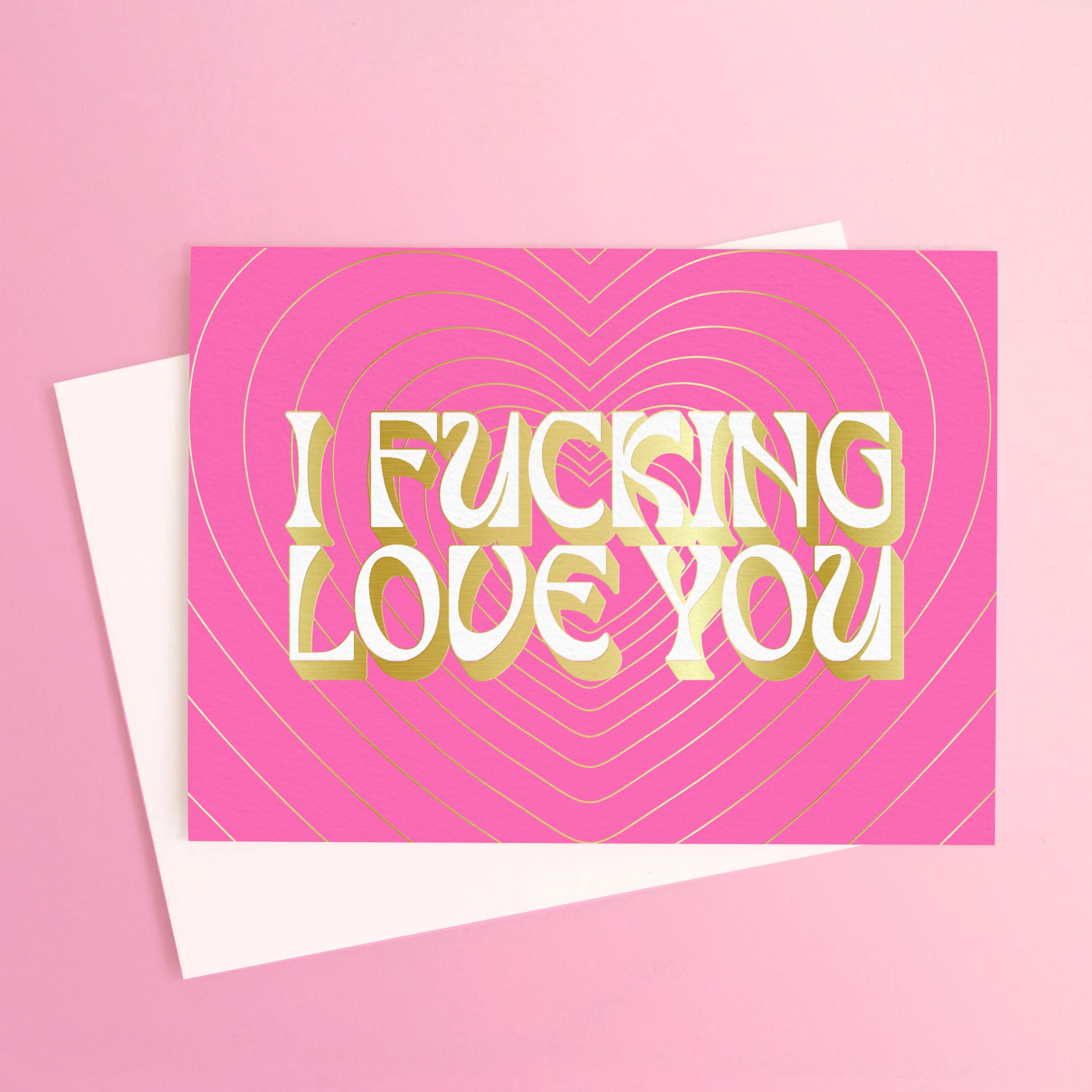 A hot pink card with gold foiled outlined text and hearts that read, 'I fucking love you'. 