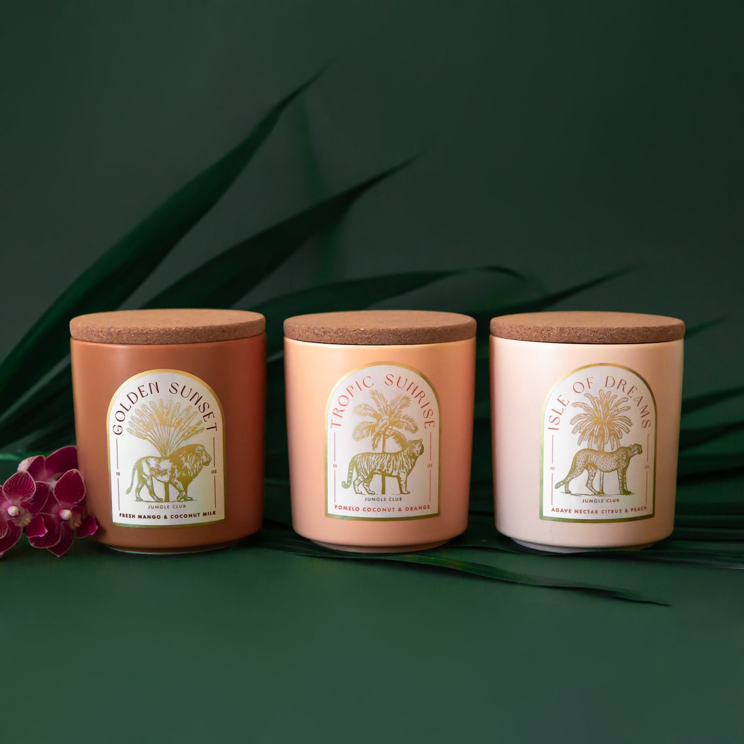 Three different candles with arched labels on them in three different scents. 