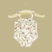 A neutral bodysuit for Minikane dolls with a light pink floral print. 