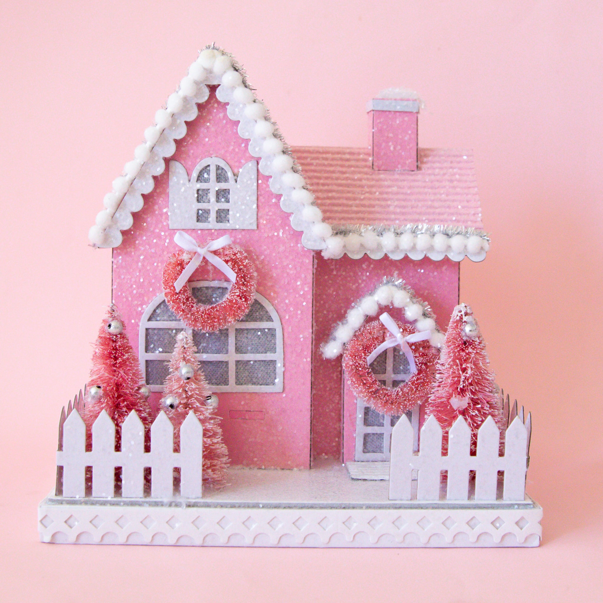 A pink adn white holiday cottage shaped figurine.