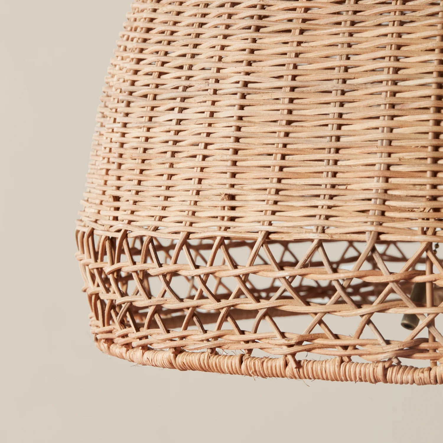 A neutral rattan floor lamp with a bamboo wrapped post and a woven domed lampshade. 