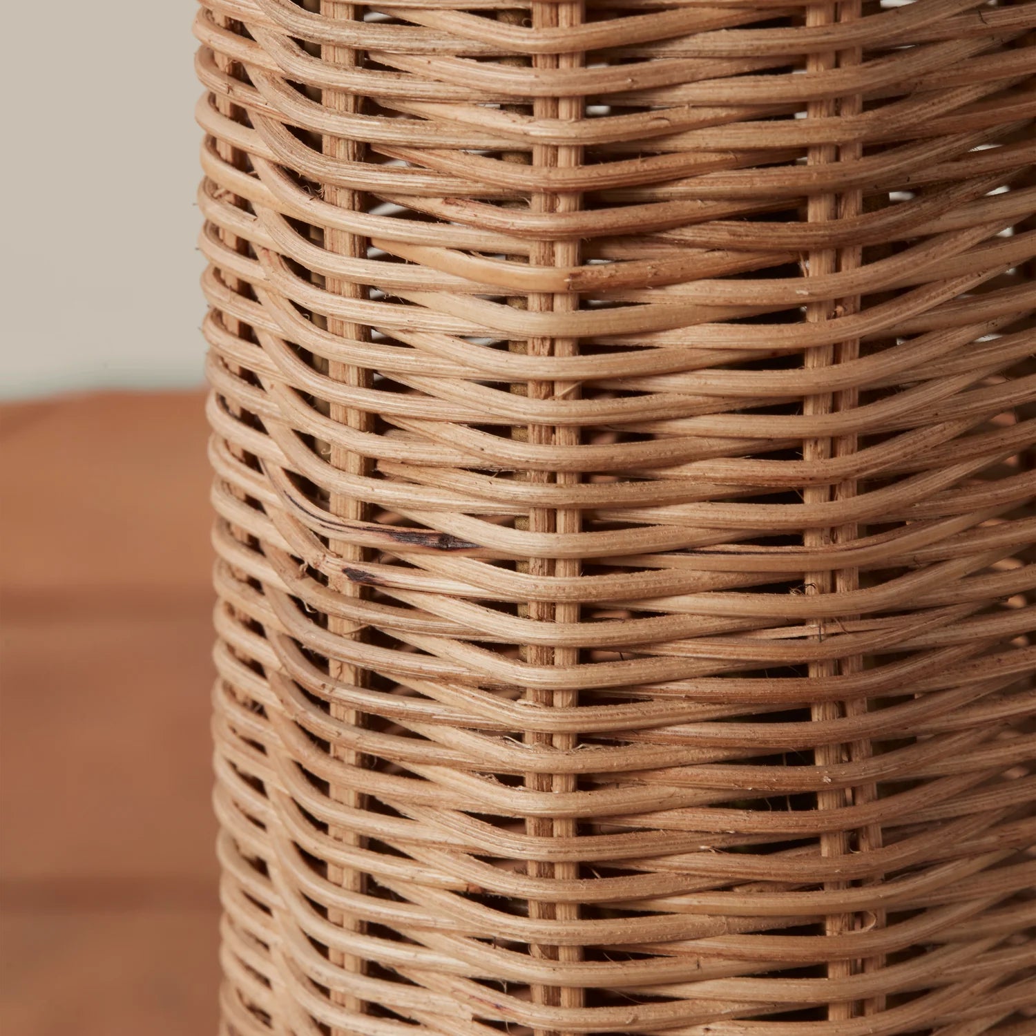 A neutral rattan floor lamp with a bamboo wrapped post and a woven domed lampshade. 