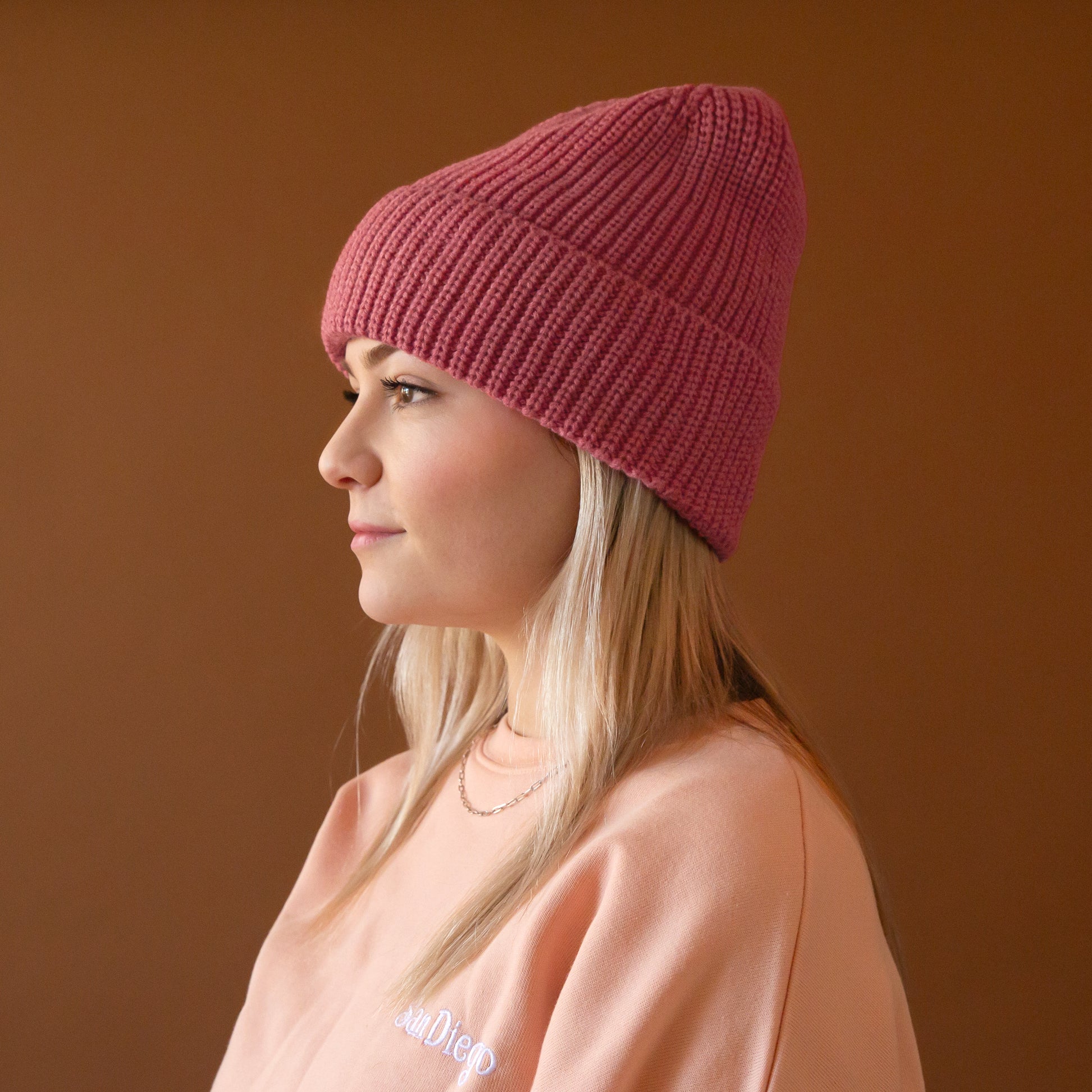 A knit beanie in a berry pink color. 