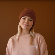 A brown knit beanie. 