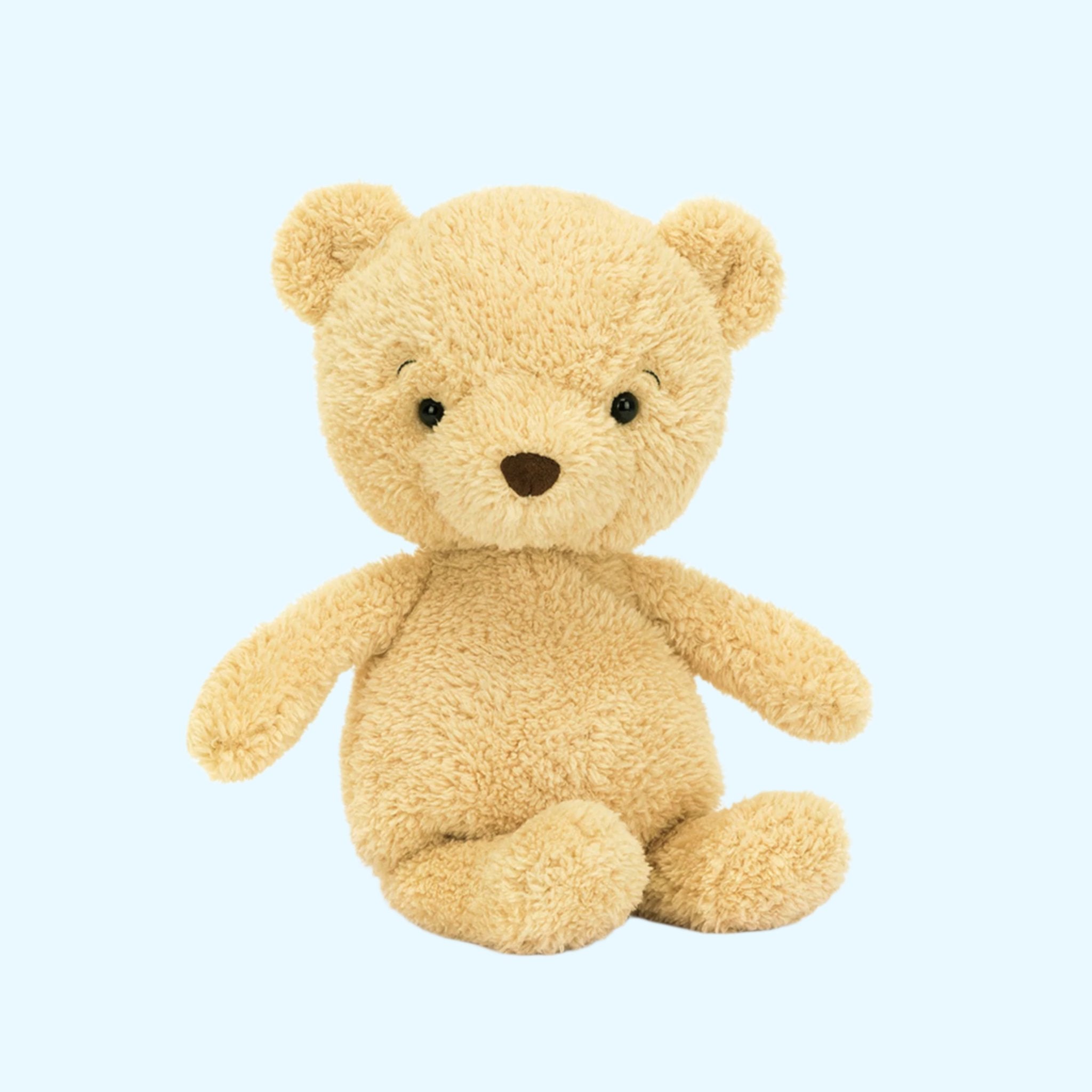 A yellow-ish beige stuffed animal bear. 