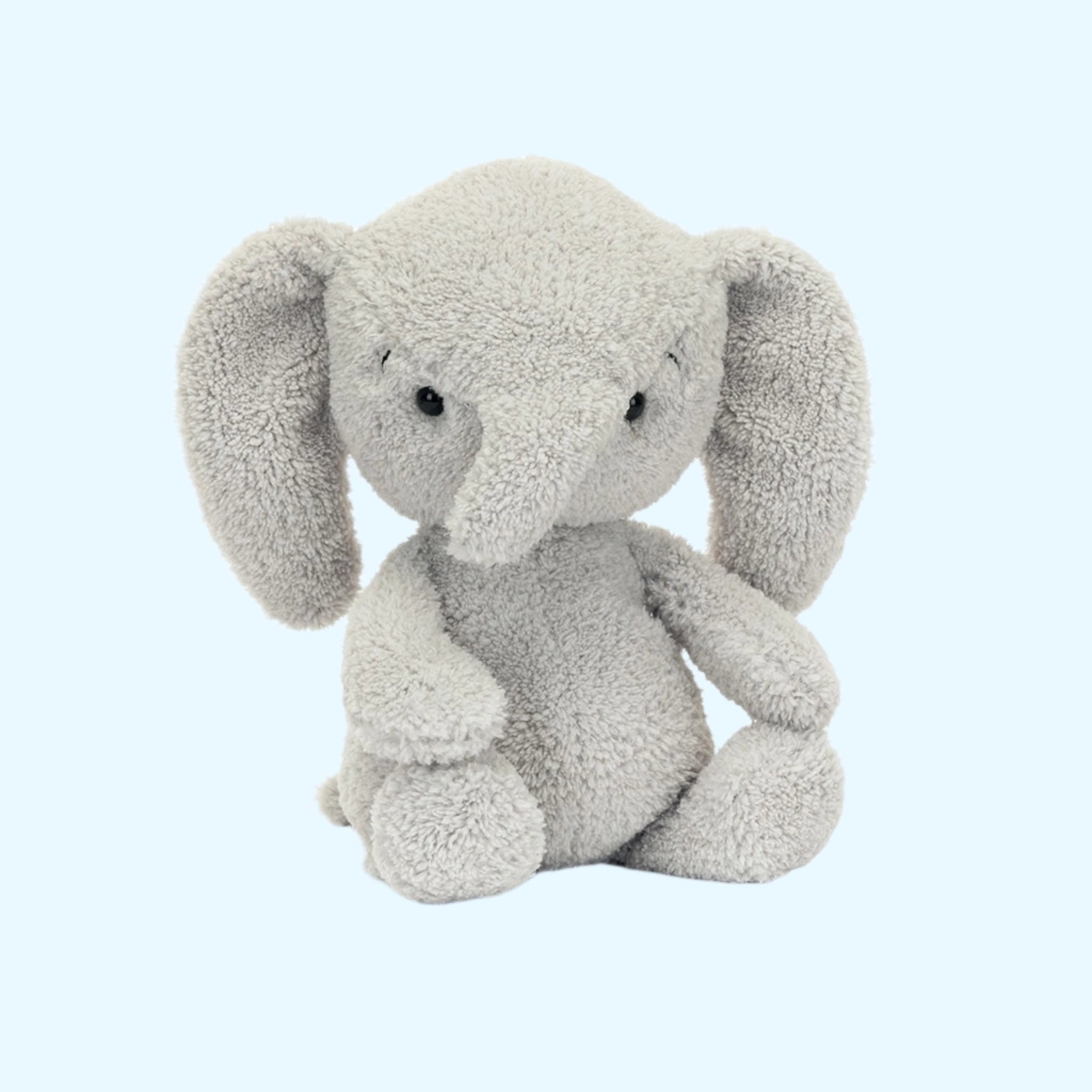 A grey elephant shaped stuffed animal. 