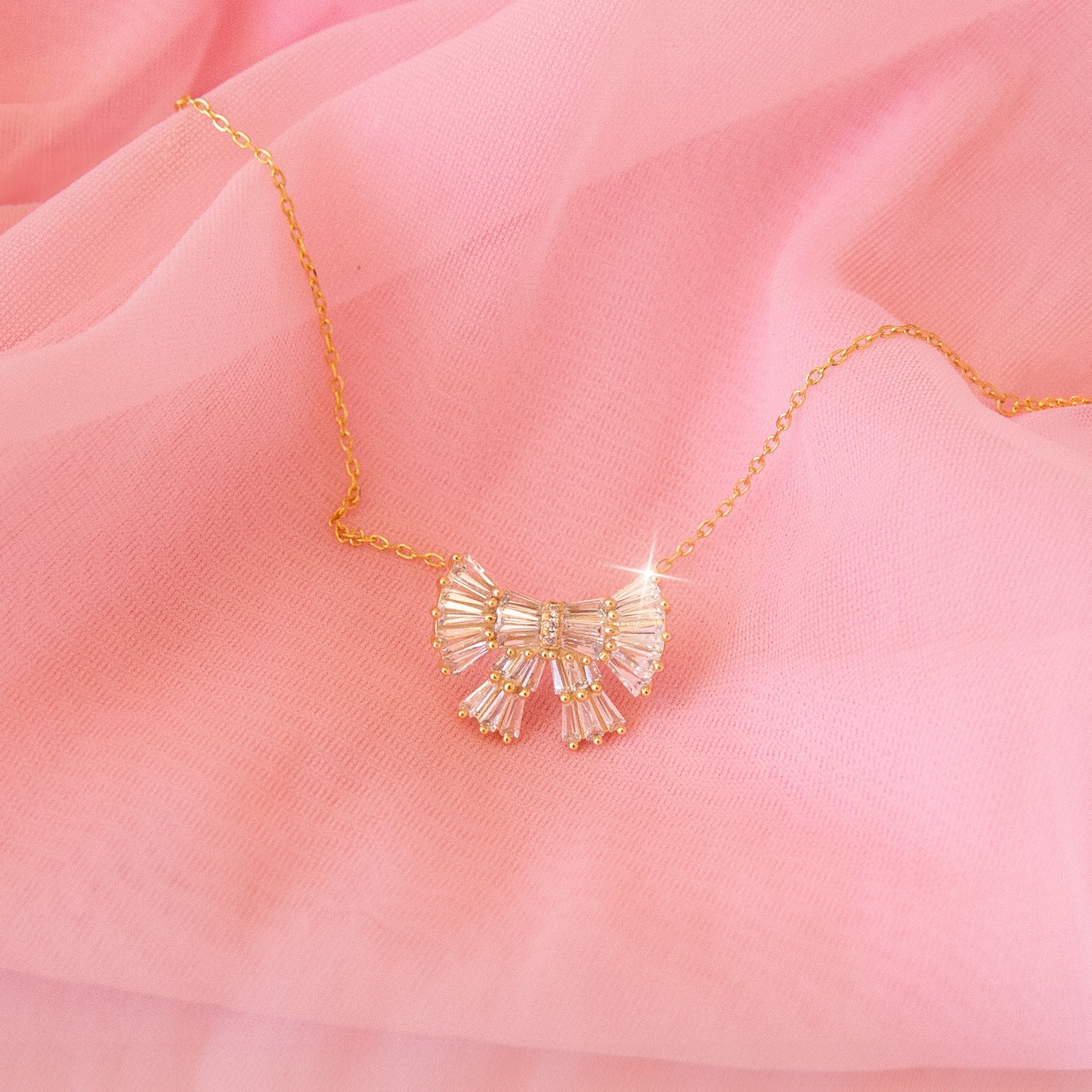 CZ baguette bow necklace with gold detailing.