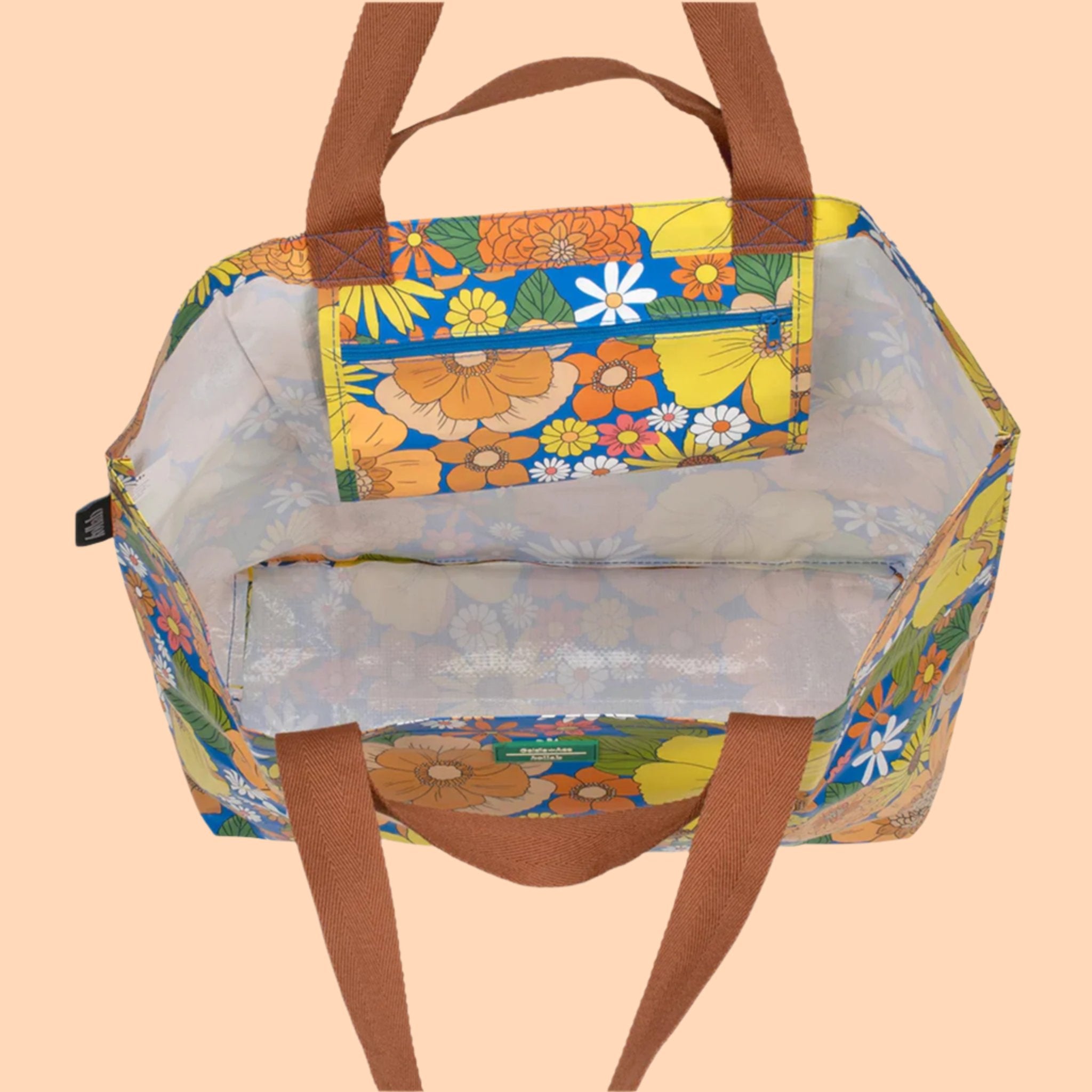 A multi colored floral tote with brown canvas handles. 