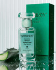 A box of perfume and a clear bottle with a teal blue label on the front that reads, "After Sun Scent of the Illustrious". 